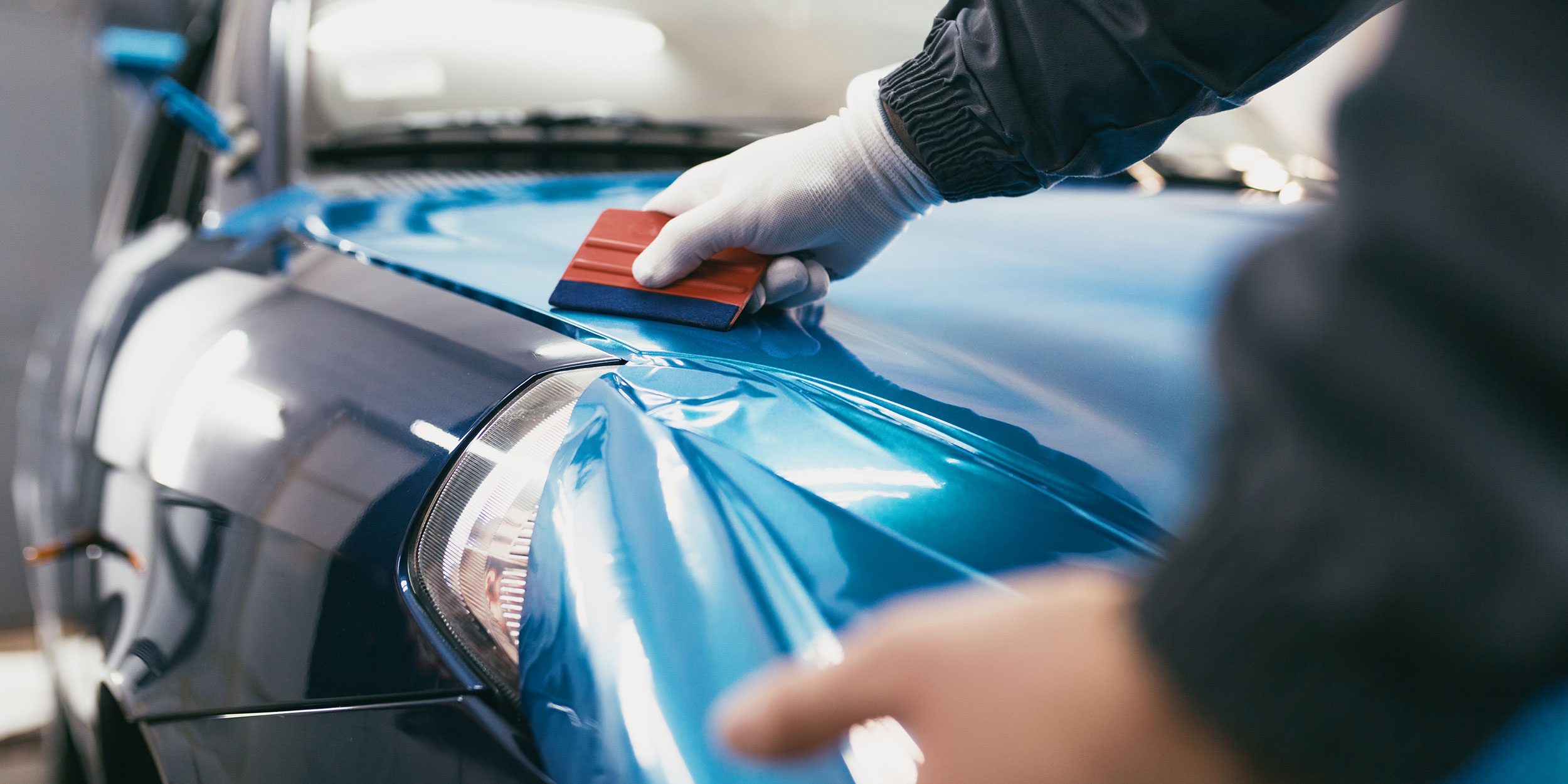 Ein Fahrzeug wird mit blauer Folie beklebt